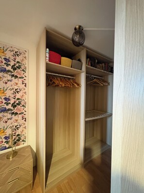 A walk-in closet with wooden doors, shelves, and hanging space. - Ground-floor apartment, terrace, a 15-minute walk from downtown Arles (Arles)