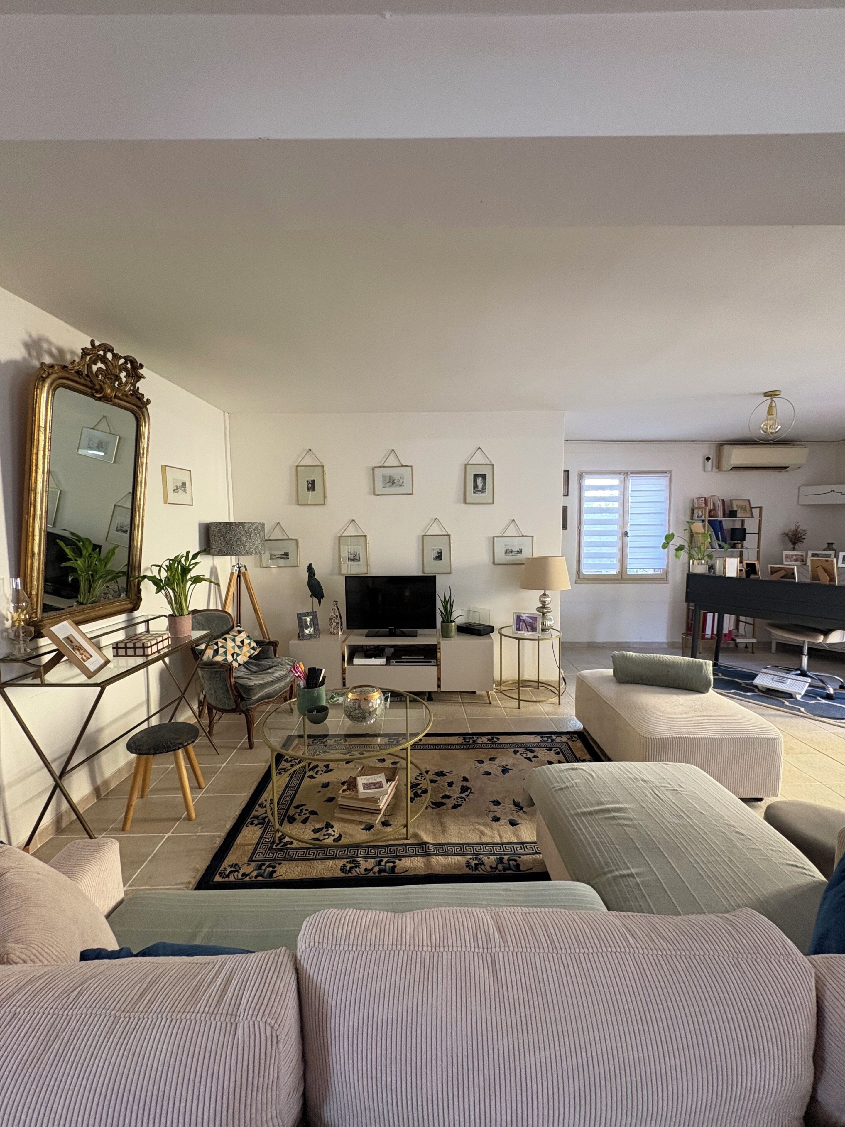 A living room with a television, sofa, coffee table, and decorative items.