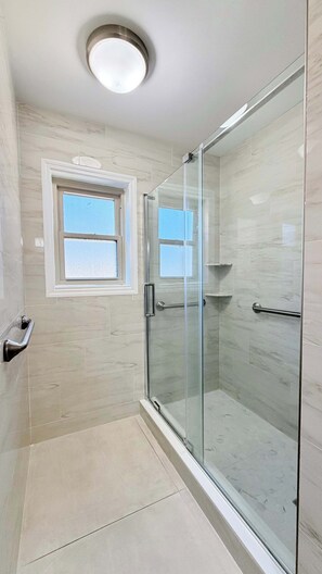 Regadera, secadora de cabello, toallas, papel de baño 