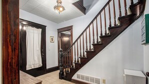 A staircase with wooden balusters and a handrail, leading to an upper floor. - 5 BR, 2 BA home in Downtown Ludington, Sleeps 14. (Ludington)