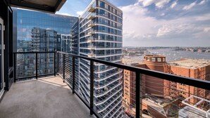 Ein Balkon mit Blick auf moderne Hochhäuser und einen Fluss.