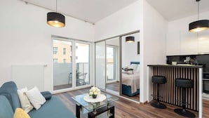 Un appartement moderne comprenant un espace de vie, une cuisine et un balcon.