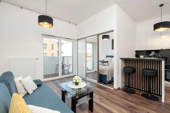 Un apartamento moderno con sala de estar, cocina y balcón.