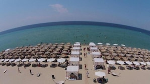 A beach with numerous umbrellas and tents, suggesting a resort setting. - Heraklia villa sea view pool & jacuzzi (XALKIDIKI)