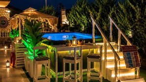 An outdoor pool area with a bar, seating, and a staircase leading up to a covered area. - Heraklia villa sea view pool & jacuzzi (XALKIDIKI)