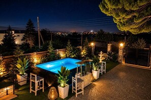 A swimming pool with a view of a cityscape at night.
