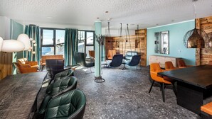 Une salle de conférence moderne, dotée d’une grande table, de plusieurs chaises et d’un plafond haut orné d’un motif moucheté.