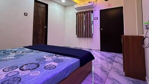 Een slaapkamer met een bed, plafondventilator, airconditioning en een marmeren vloer.