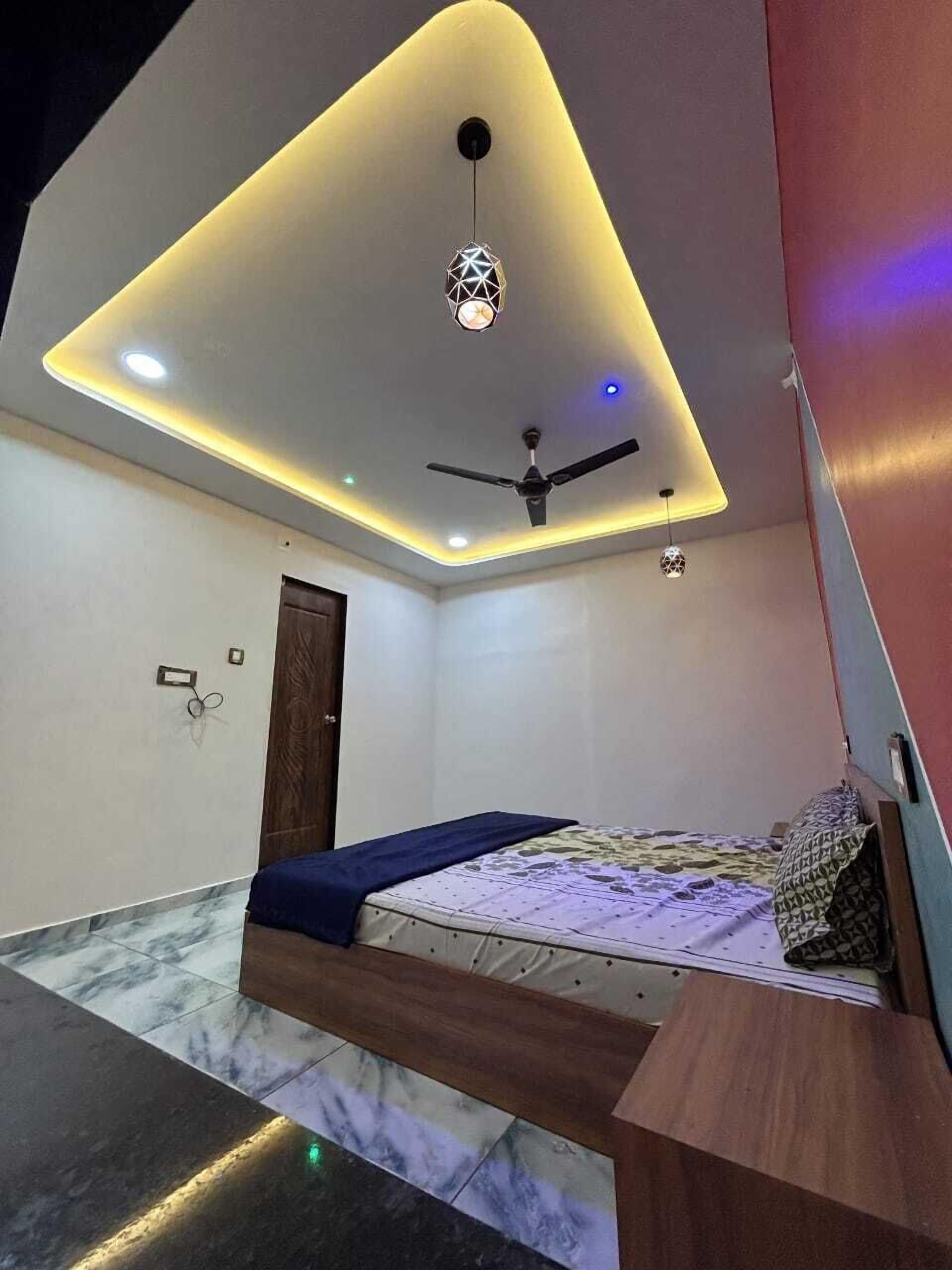 Egy modern hálószoba, amelyben található egy ágy, egy mennyezeti ventilátor és beépített világítás.