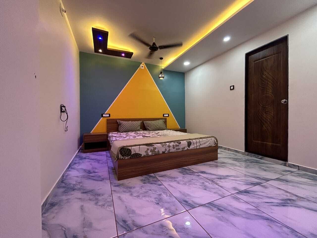 A bedroom with a bed, a ceiling fan, and a door.
