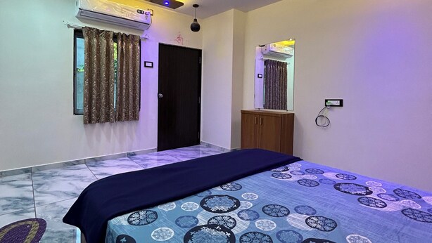 Een slaapkamer met een bed, plafondventilator, airconditioning en een deur.
