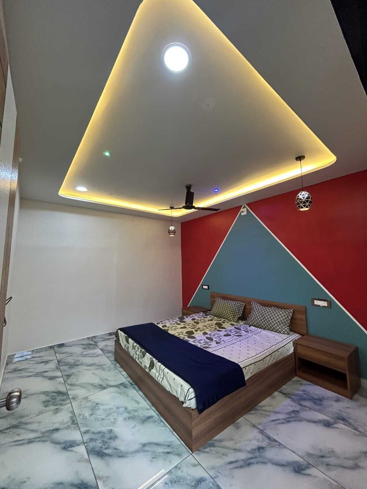 A bedroom with a bed, a nightstand, a ceiling fan, and a wall-mounted light fixture.