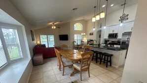 A modern kitchen with white cabinets, a built-in microwave, and a stainless steel refrigerator.