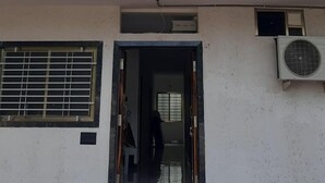 Ένα κτίριο με μια πινακίδα που αναγράφει «Gurukrupa Yatri Niwas» και έναν αριθμό τηλεφώνου επικοινωνίας.