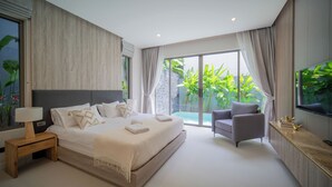 A modern bedroom with a large bed, a nightstand, a TV, and a view of a garden through the window. - Zenithy 3BR Villa with Pool by NLA (Choeng Thale)