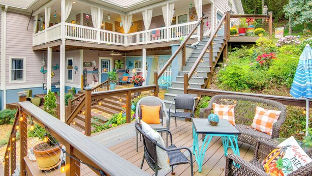 A two-story house with a deck, outdoor seating, and a staircase. - Blue Ridge Mtn Retreat: Porches & Creek Access (Hendersonville)