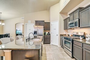 A modern kitchen with granite countertops, stainless steel appliances, and dark wood cabinetry. - Santa Teresa Home w/ Patio & Grill! (Santa Teresa)