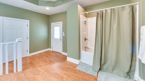 Une salle de bain avec une douche, une porte et un ventilateur de plafond.