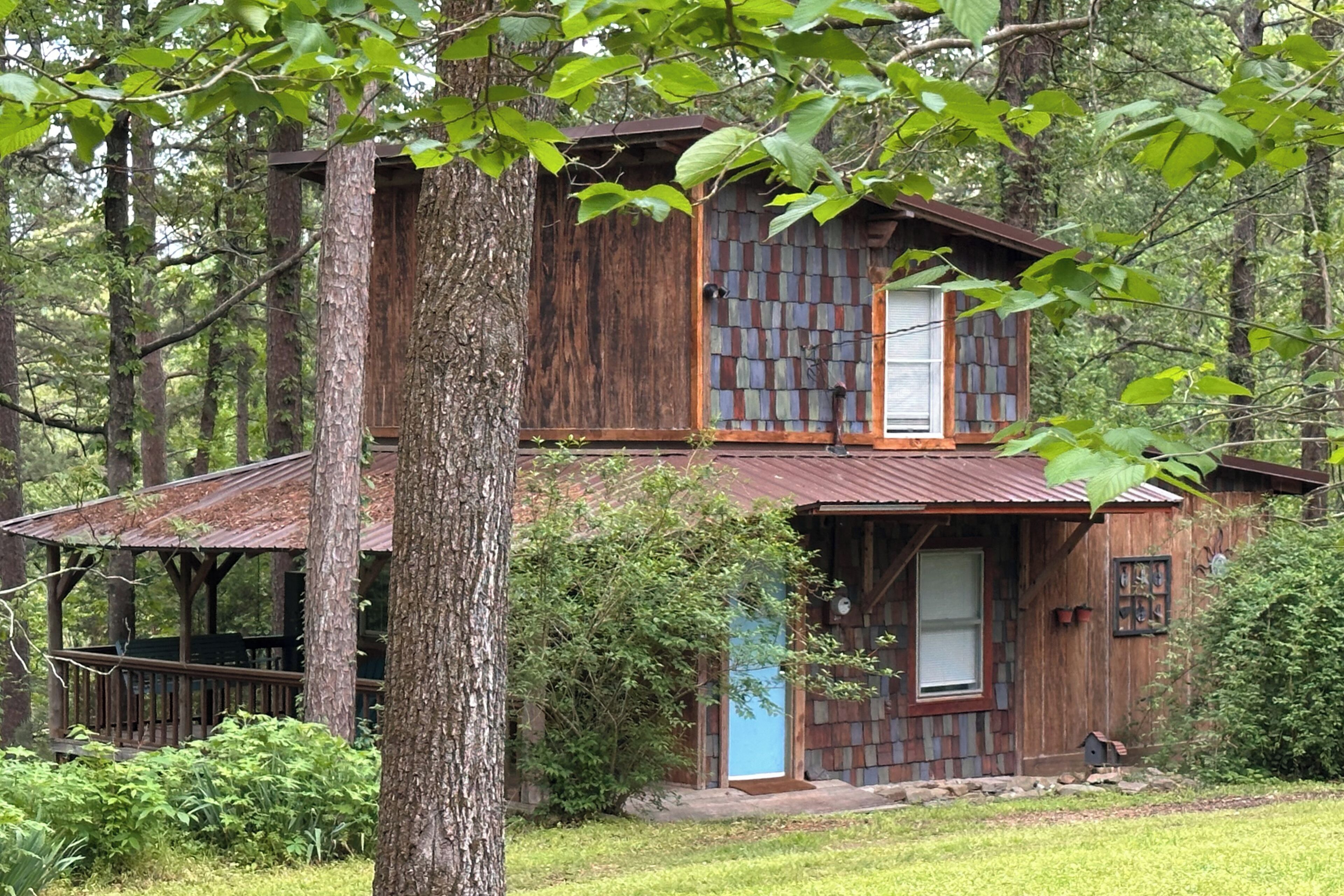 Une cabane rustique avec une façade en bois, une porte bleue et un petit porche.