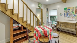 A dining area with a wooden staircase, a striped tablecloth, and a bench. - Mountain View Cabin: Music, Crafts & Shopping! (Mountain View)