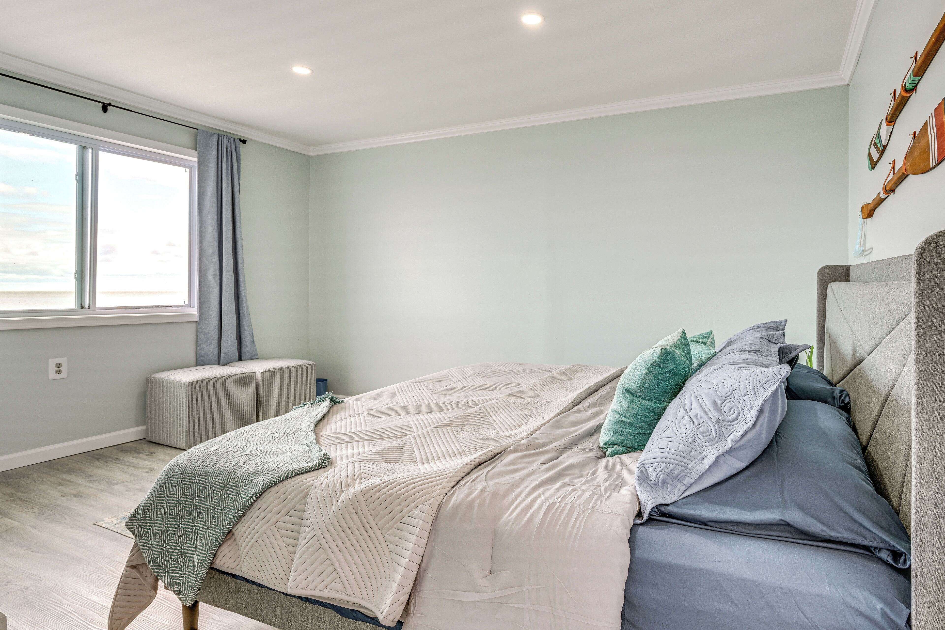Un dormitorio con una cama grande, una ventana con cortinas y vista al cielo.