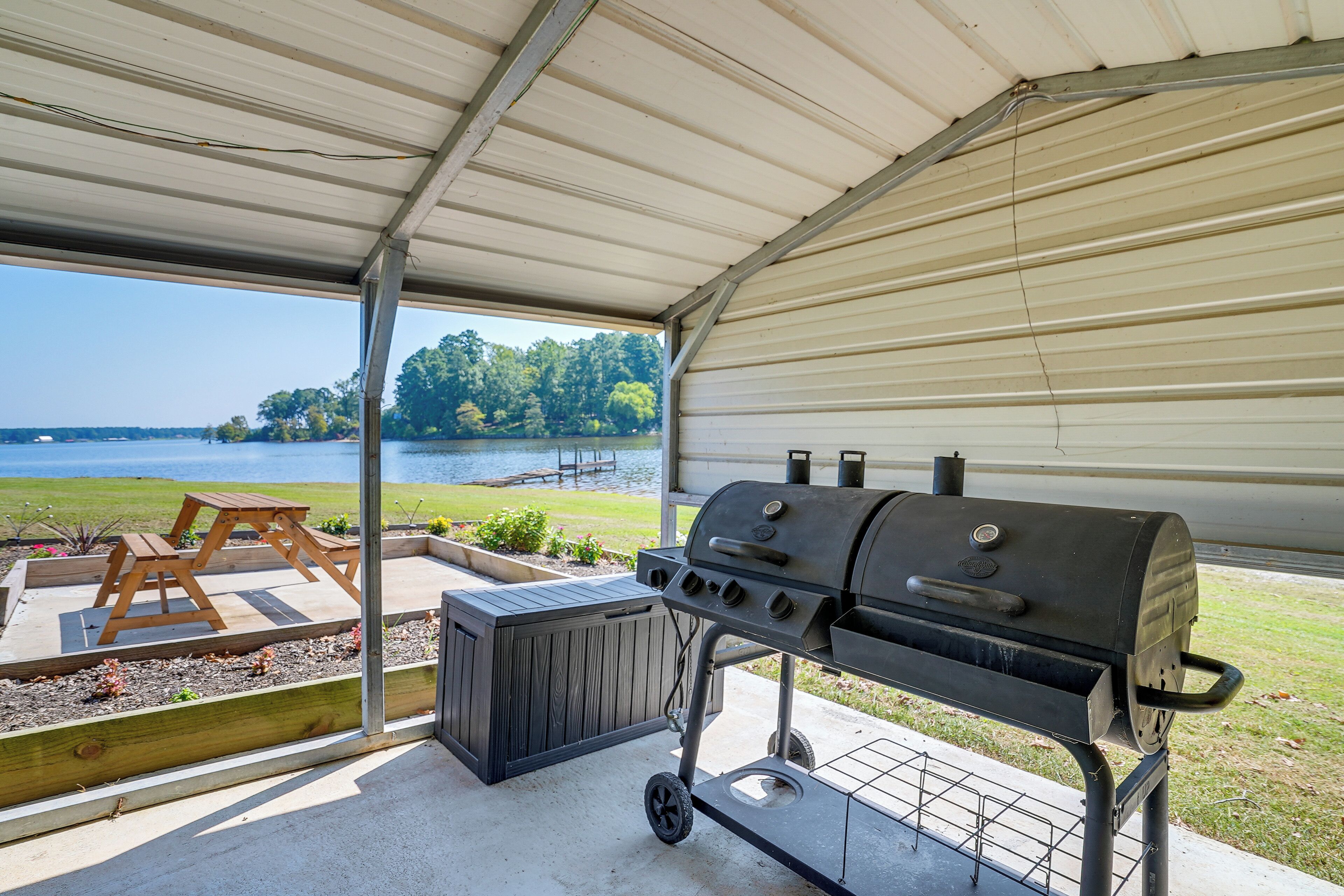 Une terrasse extérieure équipée d’un barbecue, d’une table de pique-nique en bois et d’un jacuzzi.