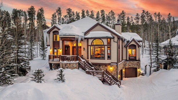 A large, two-story lodge with a stone facade, multiple windows, and a snow-covered roof. - Short Walk to Ski Lifts | Boulder Ridge Retreat (Breckenridge)