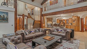 A spacious living area with a large sectional sofa, a chess table, and a kitchen in the background. - Short Walk to Ski Lifts | Boulder Ridge Retreat (Breckenridge)