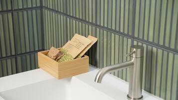 A wooden box with tea bags on a white sink.