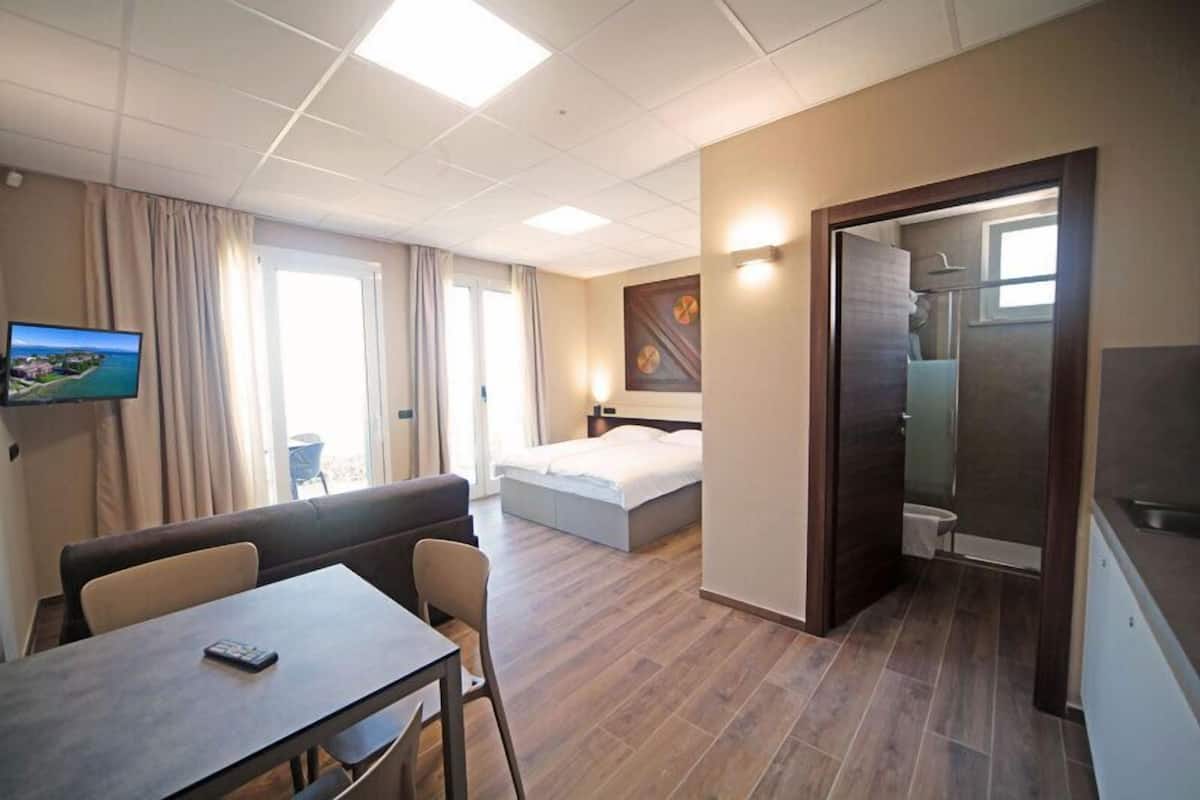A hotel room with a bed, a desk, a TV, and a bathroom.