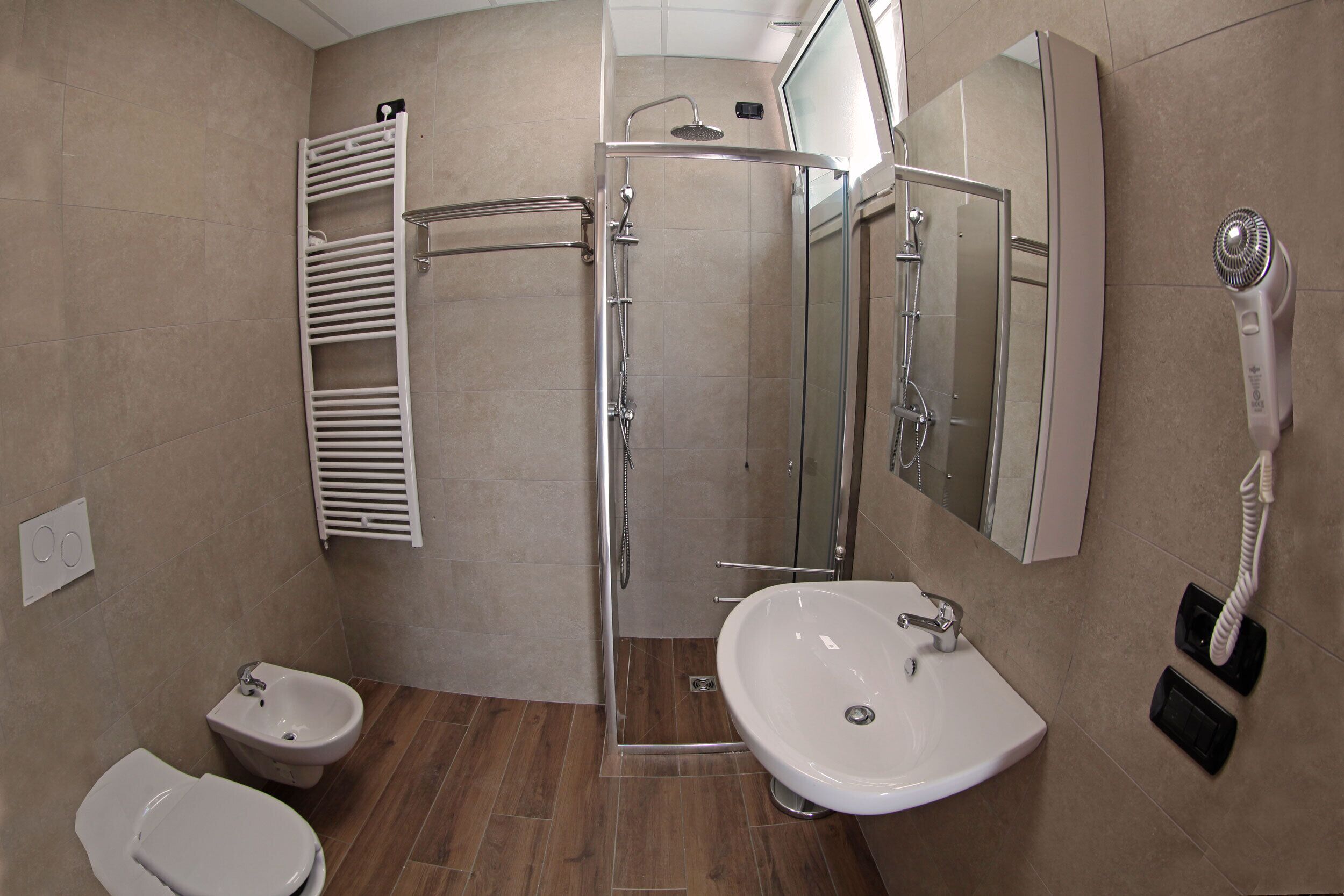 Een badkamer met douche, toilet, wastafel en bidet.