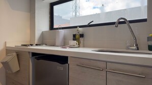 A modern kitchen with a white countertop, stainless steel sink, and a window above the sink. - w Marvelous Loft w Modern Deco in Bogota (Bogotá)