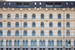 A multi-story building with a symmetrical facade, featuring evenly spaced windows and a consistent architectural style. - Stunning Seafront Apartment With Modern Comforts and Dike Views (Ostend)