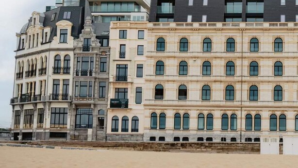 A modern building with multiple balconies and a traditional building with arched windows. - Stunning Seafront Apartment With Modern Comforts and Dike Views (Ostend)