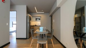 A modern kitchen with a microwave, refrigerator, and wooden dining table with chairs. - w Resplendent 2BR w Great Balcony in San Isidro (Lima)