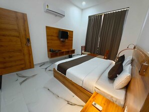 Relax in a spacious room with a large bed, flat-screen TV, and large window.