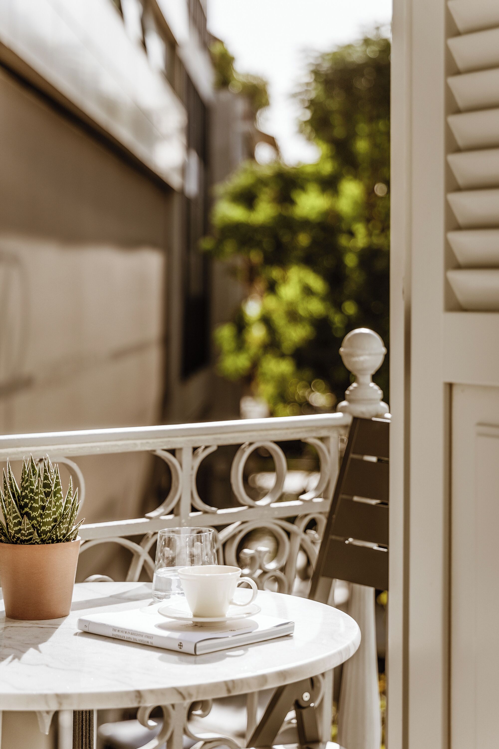 A round table with a potted plant, a cup, and a book.