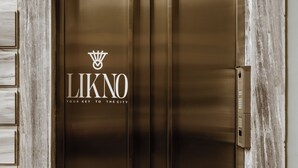 A metallic elevator door with the logo "LIKNO" and the tagline "YOUR KEY TO THE CITY" on it. - Likno Athens (Athens)