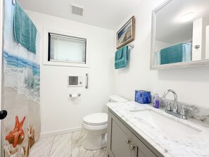 A bathroom with a toilet, sink, and shower.