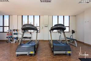 A gym with treadmills, weight machines, and a rack of dumbbells. - Apartamento no hotel Comfort (Taguatinga)