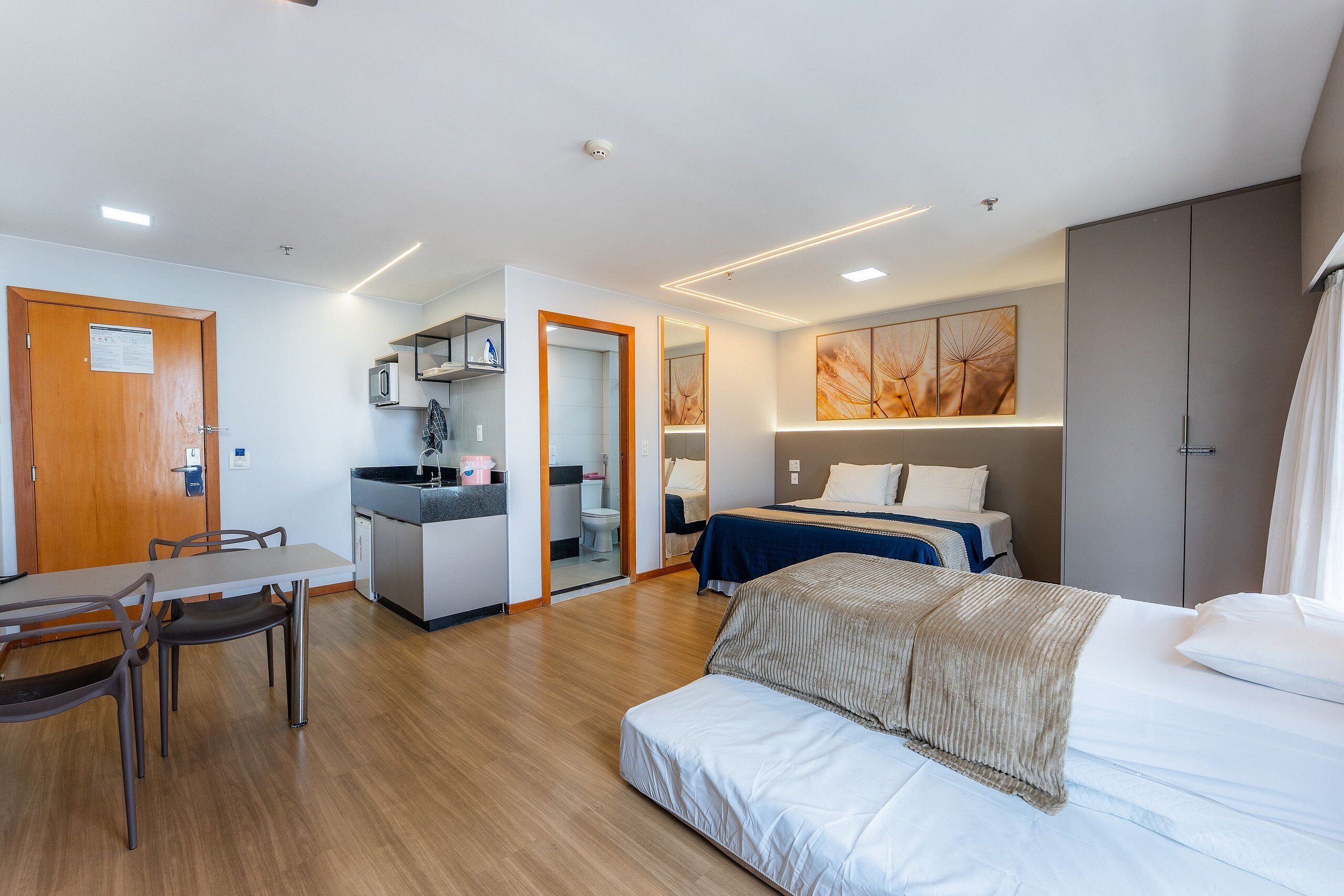 Une chambre d’hôtel moderne équipée d’un lit, d’un bureau et d’une kitchenette.