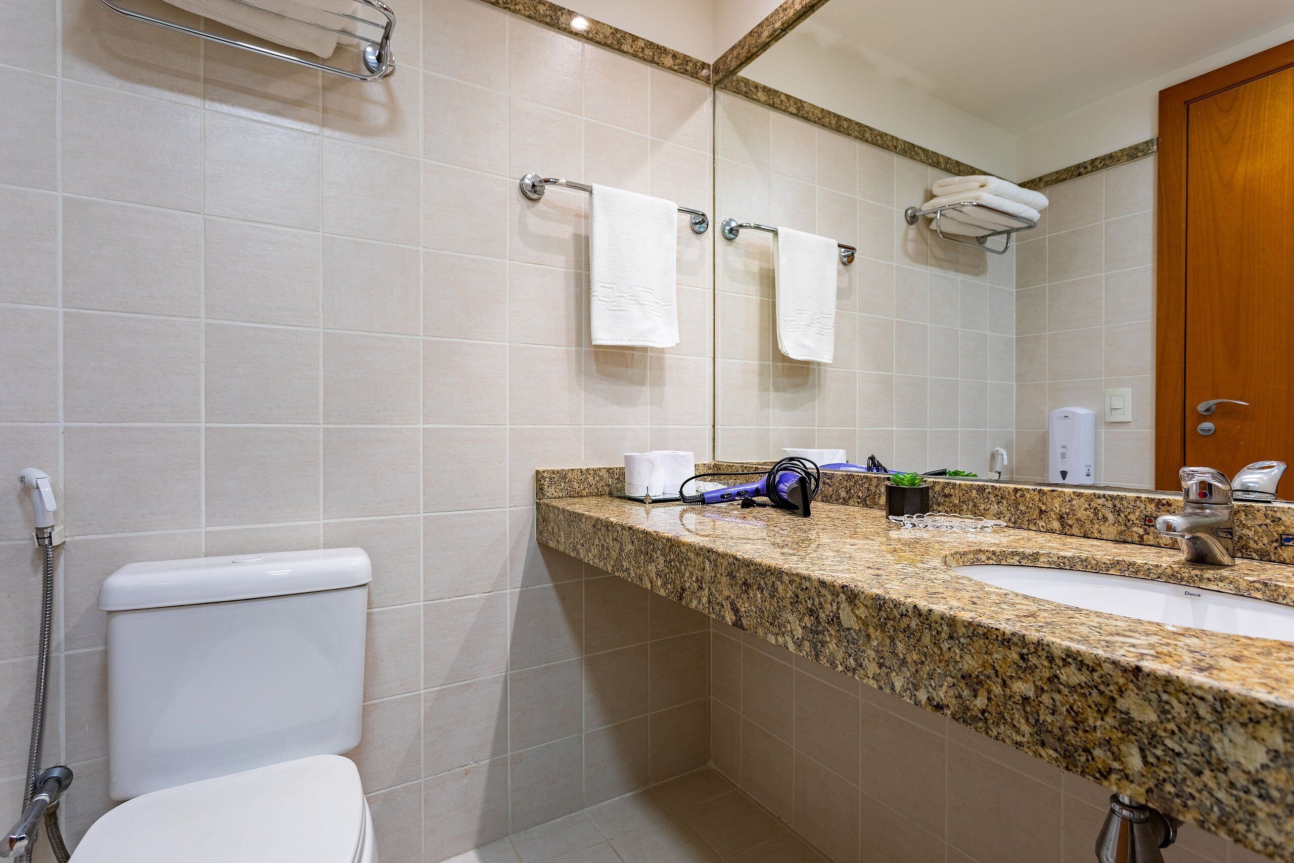 A bathroom with a toilet, sink, and shower.