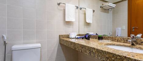 A bathroom with a toilet, sink, and shower.