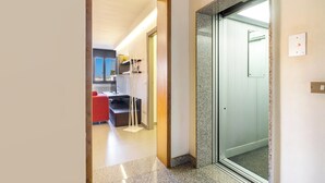A hallway leading to a room with a door, a red chair, and a small table. - 4021 Casa Dolce Margherita by Barbarhouse (Casarano)