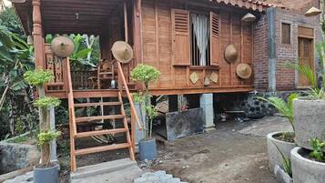 Una casa de fusta tradicional amb teulada de teules, un porxo de fusta i una escala que mena a l'entrada.