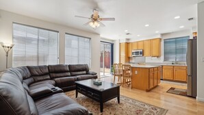 A modern living room with a sectional sofa, a coffee table, and a ceiling fan. - San Jose 5BR Home Sleeps 10, Dog Friendly (San Jose)