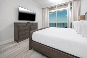 A hotel room with a bed, a dresser, a flat-screen TV, and a balcony with a view. - Phoenix Orange Beach 804 3 Bedroom Condo by RedAwning (Orange Beach)