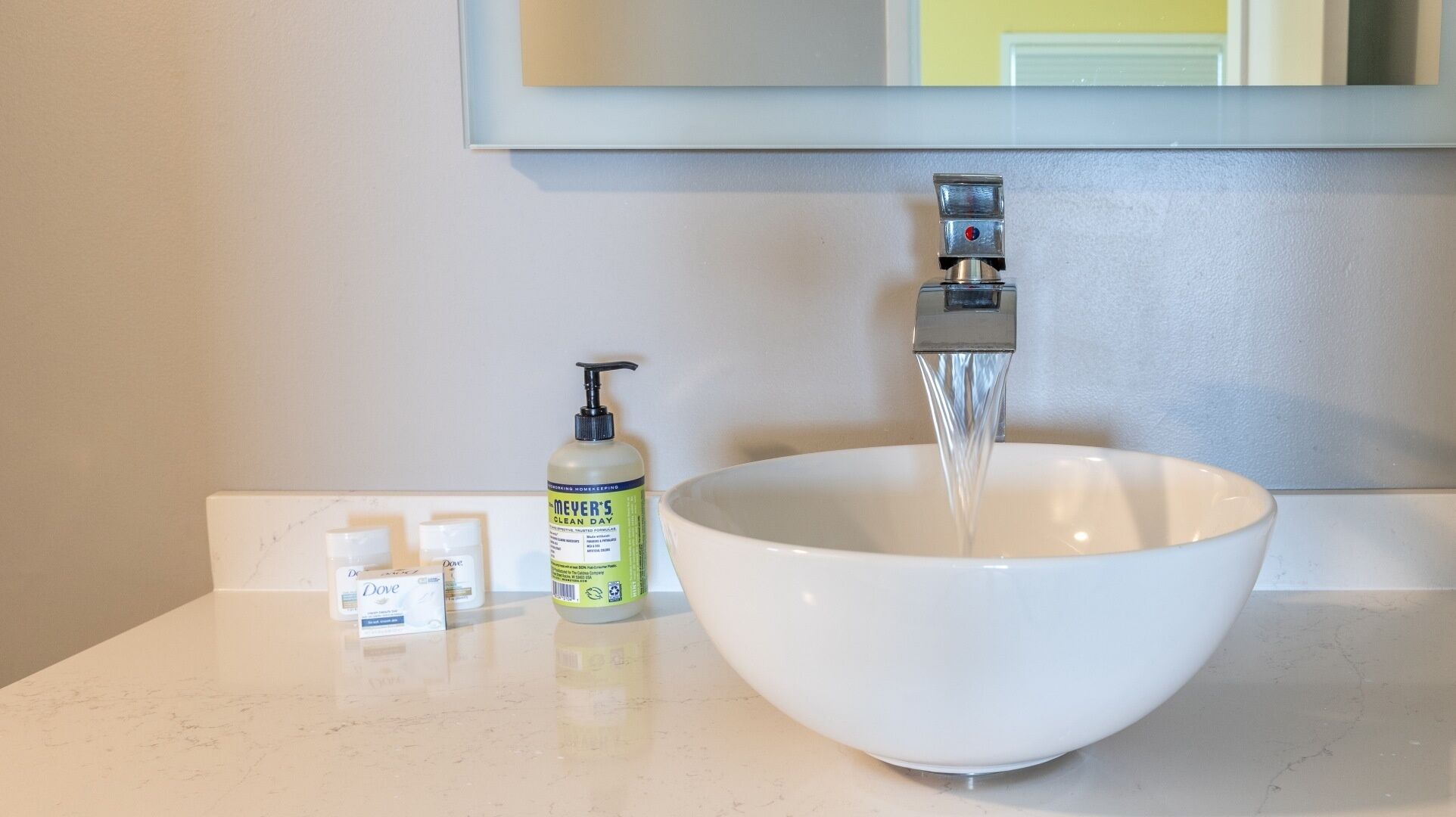 A white bathroom sink with a large bowl, a faucet, and a soap dispenser.