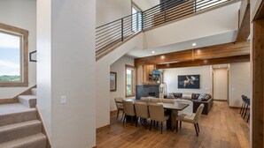 A spacious dining area with a high ceiling, wooden beams, and a view of the outdoors. - Aprez Retreat 3 Bedroom Condo by RedAwning (Winter Park)