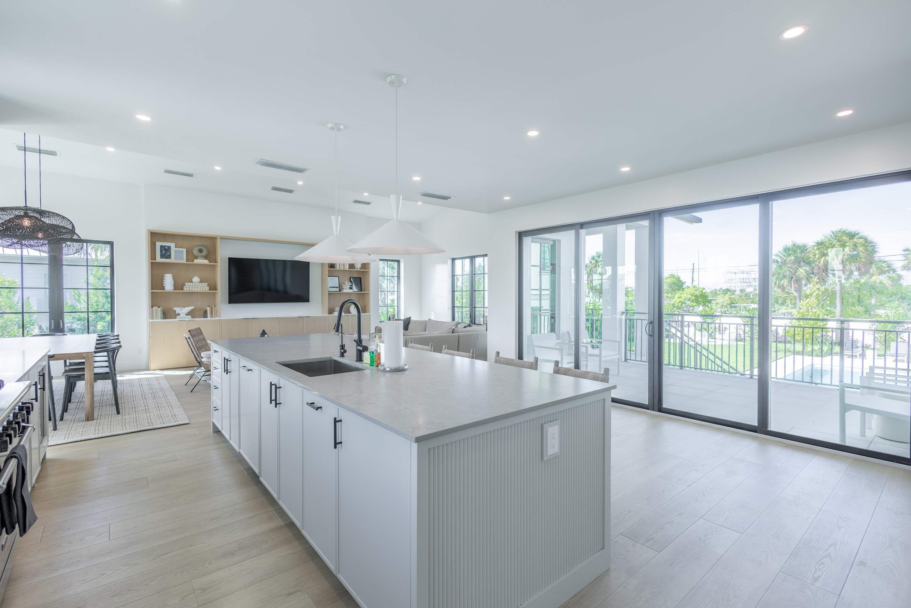 Una cocina moderna con una isla grande, comedor y un balcón con vistas.